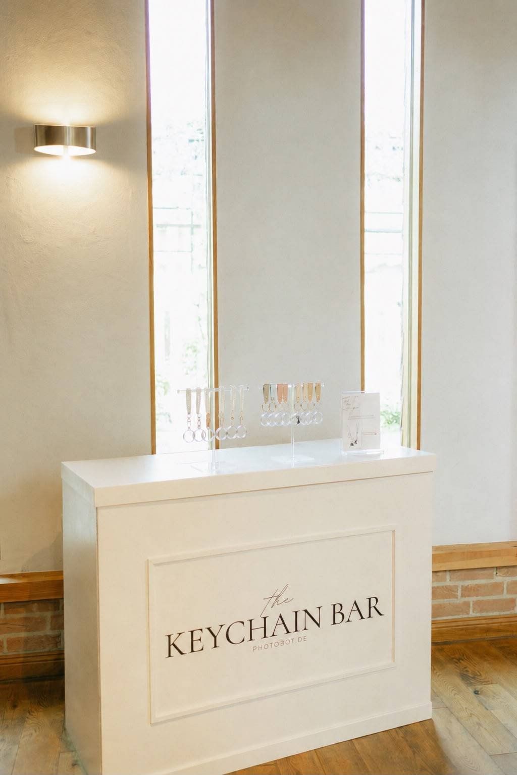 Weiße Keychain Bar von Photobot mit Ständern voller Schlüsselanhänger in einer hellen Eventlocation