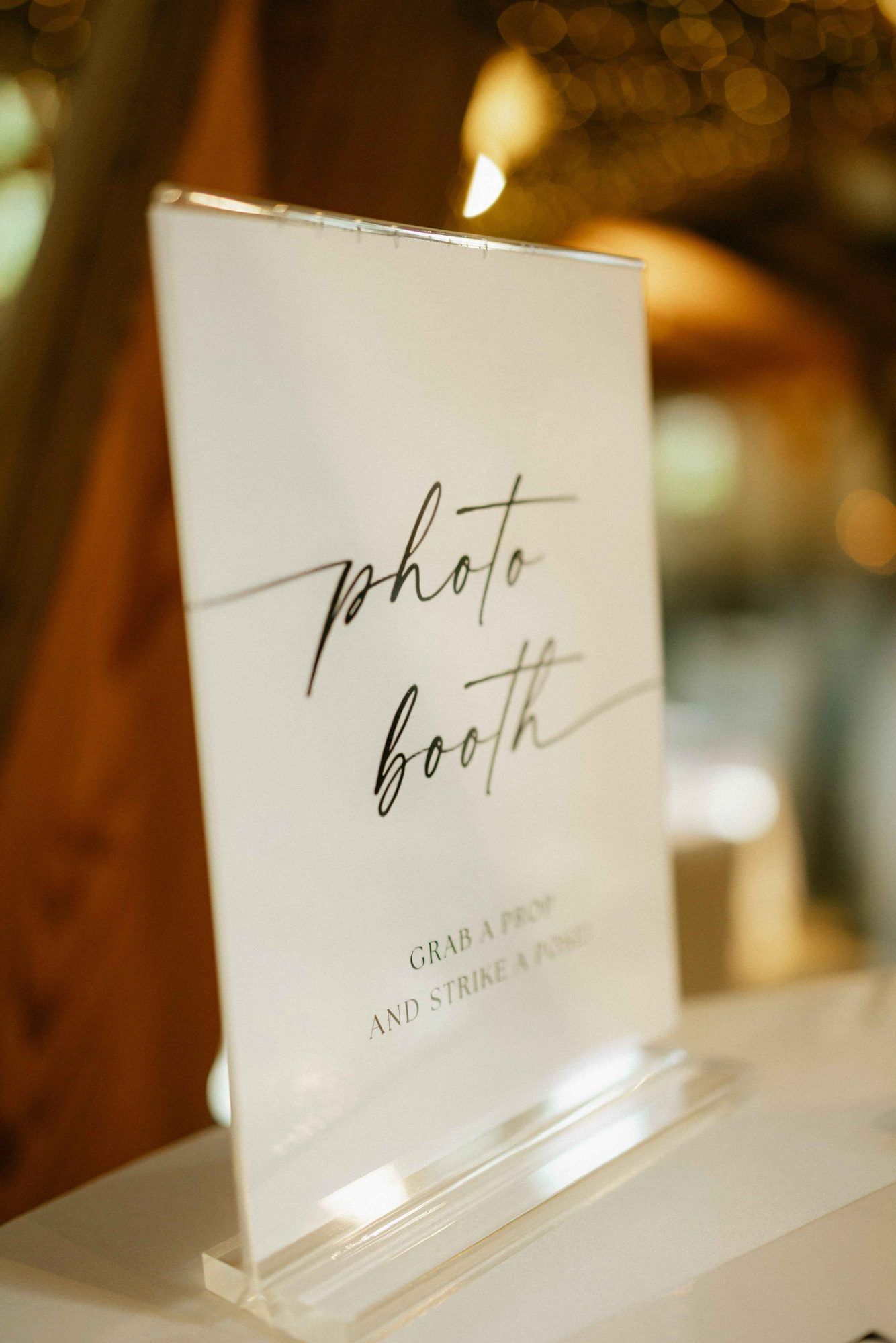 Photo-Booth-Aufsteller aus Acryl mit dem Hinweis „Grab a prop and strike a pose“