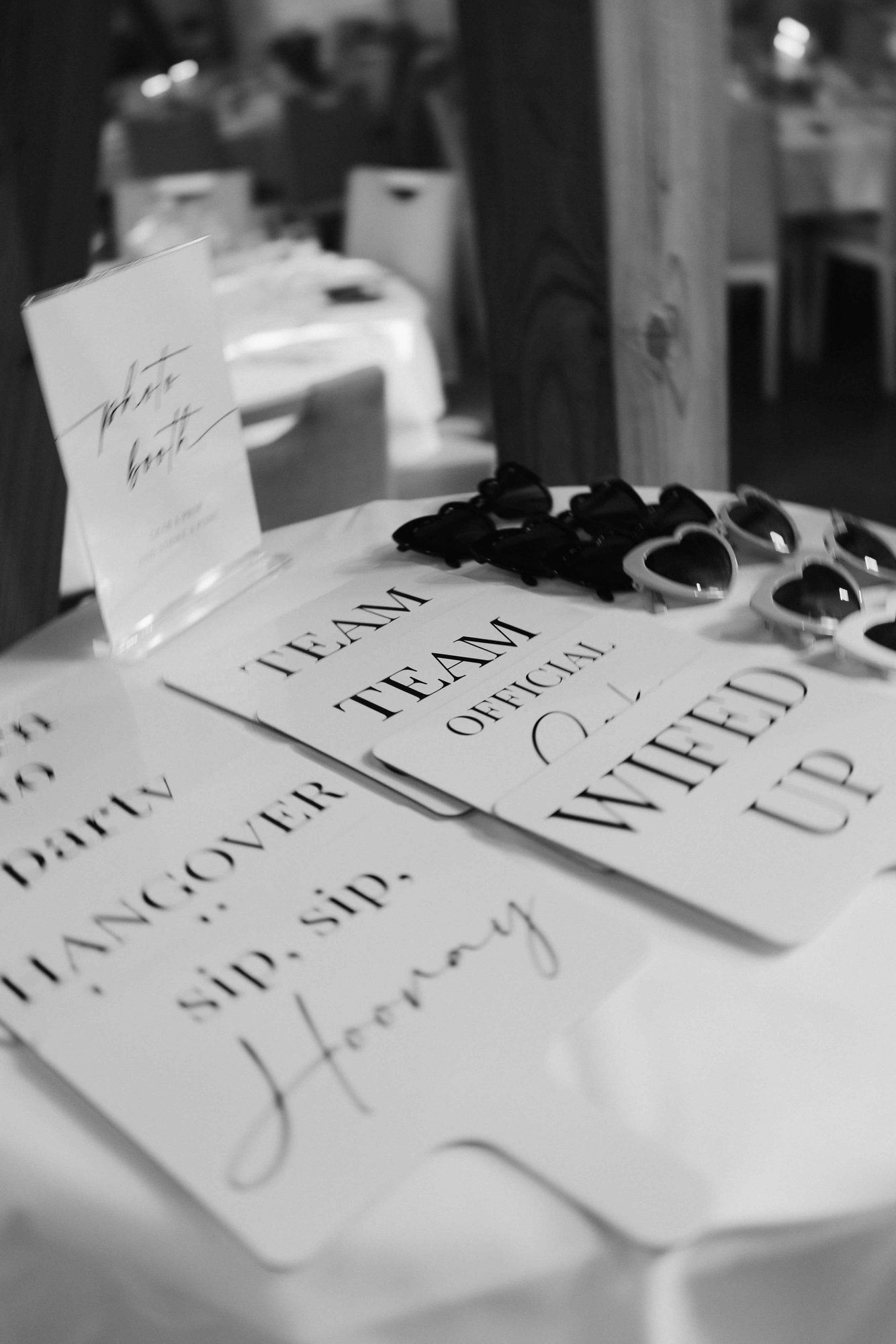 Requisiten-Schilder wie „Wifed up“ und Herzsonnenbrillen auf dem Hochzeitstisch